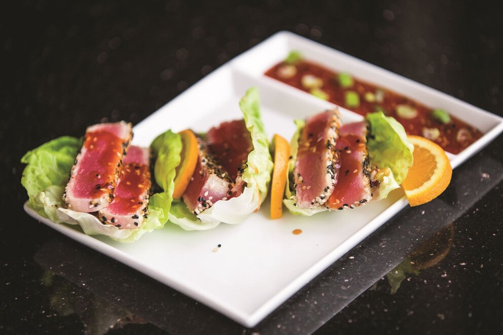tuna between lettuce and orange slices with side of sauce