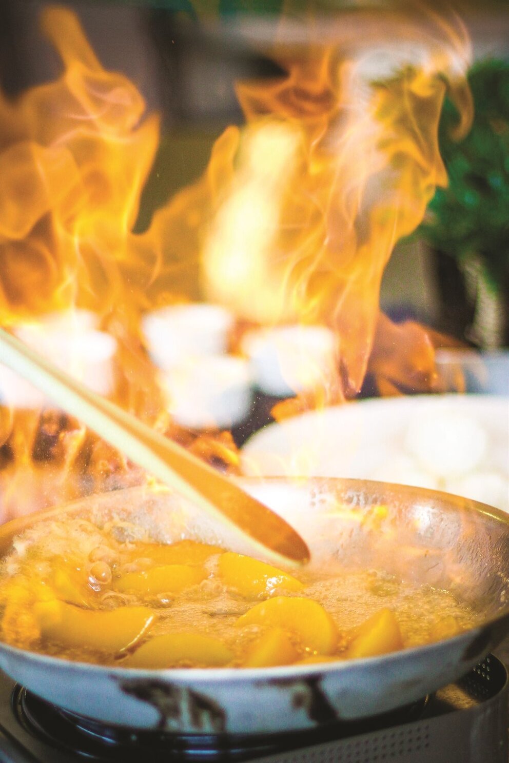peaches in a pan being flambéed