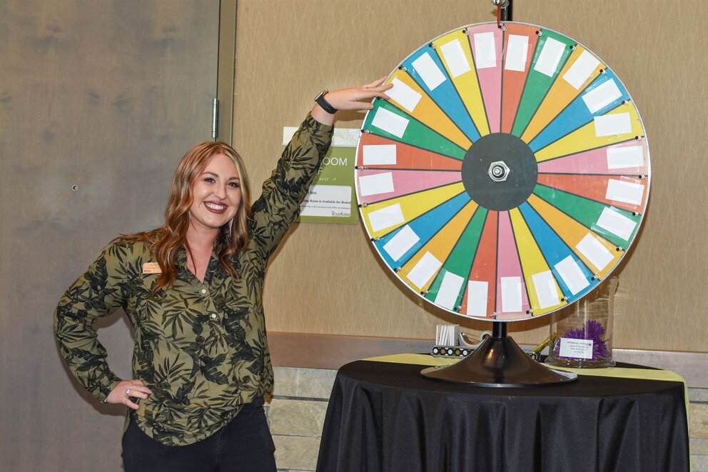 Woman standing next to a prize wheel at Texarkana Convention Center